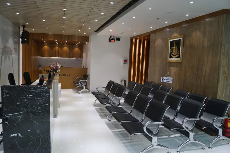 Reception and waiting area with rows of seating and a marble-clad front desk at Al-Amal Diagnostic in Kurla, Mumbai