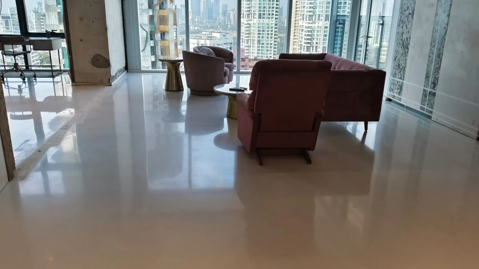 Finished high-rise living room with polished flooring and a full-height window overlooking the city
